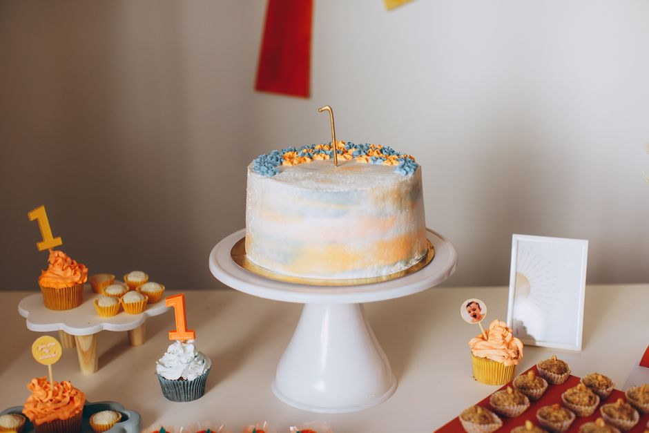 Mesa com bolo de aniversário e doces coloridos