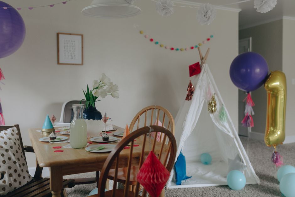 Mesa de aniversário montada em casa com doces e balões